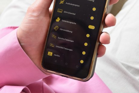 Jemand hält ein Smartphone in der Hand, auf dem die Greta-App geöffnet ist.