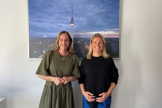 Hildegard Bentele und Verena Bentele stehen nebeneinander. Hinter ihnen hängt ein Bild an der Wand, auf dem der Berliner Fernsehturm zu sehen ist.