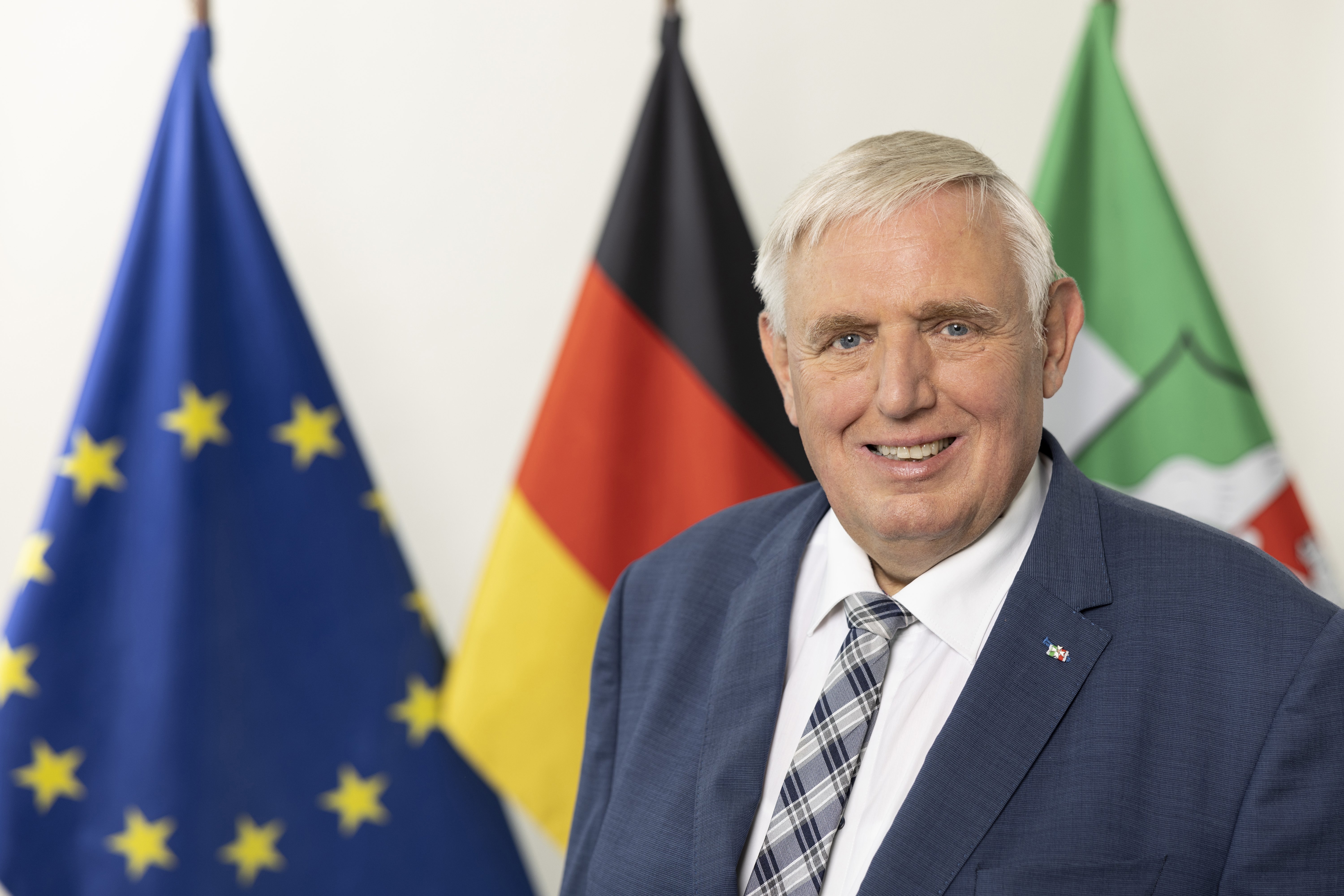 Karl-Josef Laumann Das Foto zeigt Karl-Josef Laumann, im Hintergrund sind drei Flaggen zu sehen: Die Europa-Flagge, die Deutschlandflagge und die Flagge von Nordrhein-Westfalen
