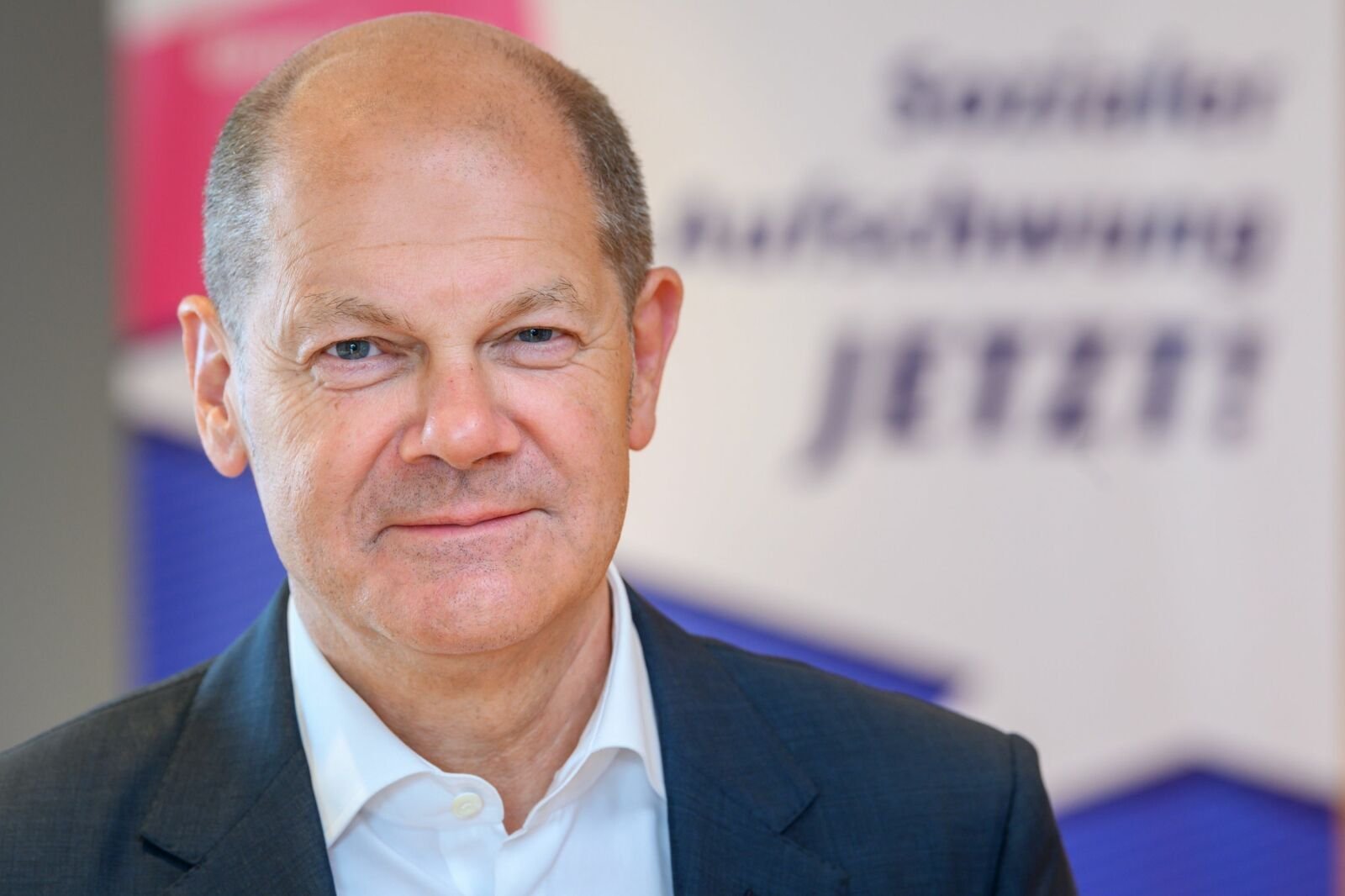 Olaf Scholz Das Portraitfoto zeigt Olaf Scholz vor dem Hintergrund der VdK-Kampagne "Sozialer Aufschwung jetzt!"