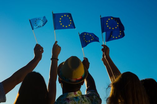 Mensche halten kleine Europaflaggen in den Himmel
