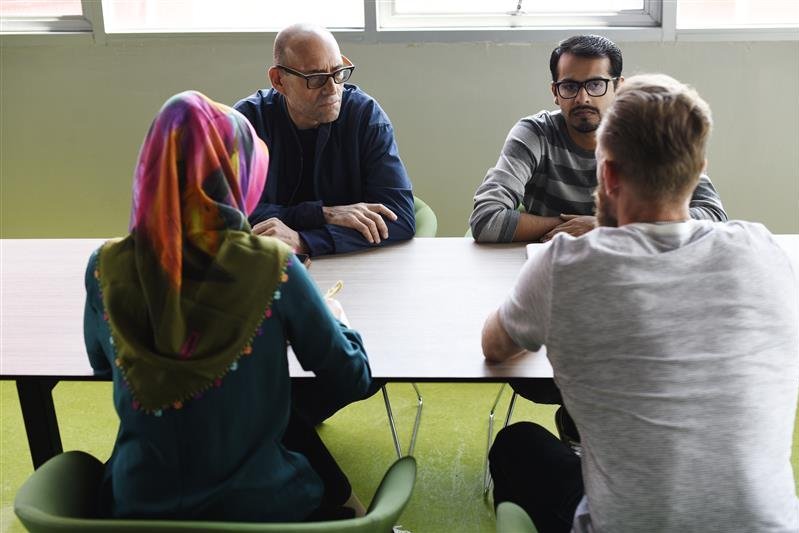 Vier Menschen sitzen um einen Tisch