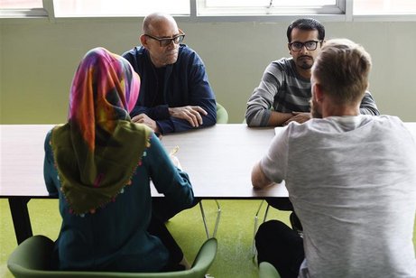 Vier Menschen sitzen um einen Tisch