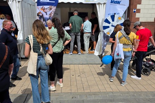 Menschen vor einem Pavillon.