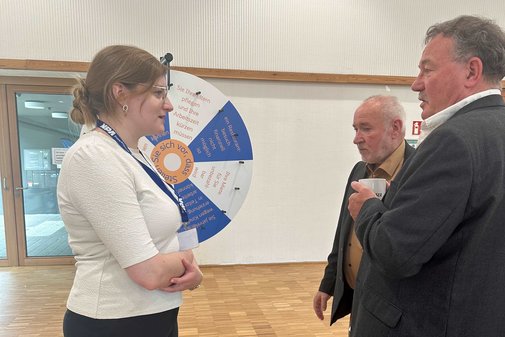 Eine Frau udn zwei Männer im Gespräch.