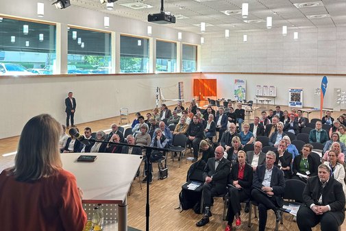 Eine Rednerin vor Publikum.