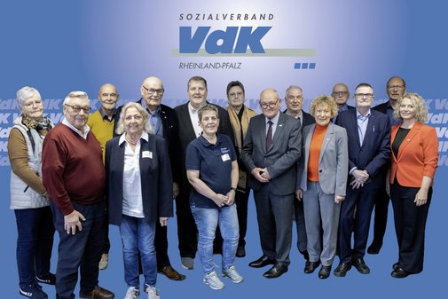 Gruppenfoto von Frauen und Männern vor einem blauen Hintergrund mit VdK-Logos.
