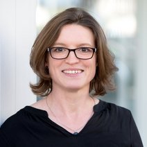 Porträtfoto einer Frau mit braunen Haaren und Brille.