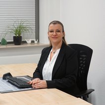 Eine Frau sitzt an einem Schreibtisch.