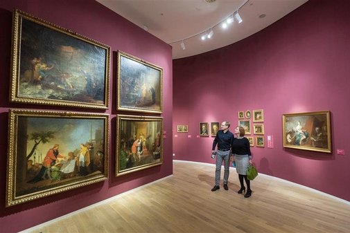 Eine Frau nund ein Mann betrachten gro&szlig;e Gem&auml;lde in einem Museum.