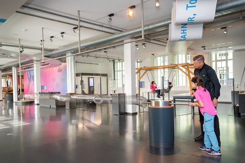 Ein Mann und ein Kind in einem Technikmuseum.