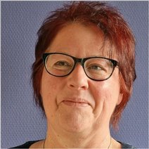 Porträtfoto einer Frau mit kurzen Haaren und Brille.