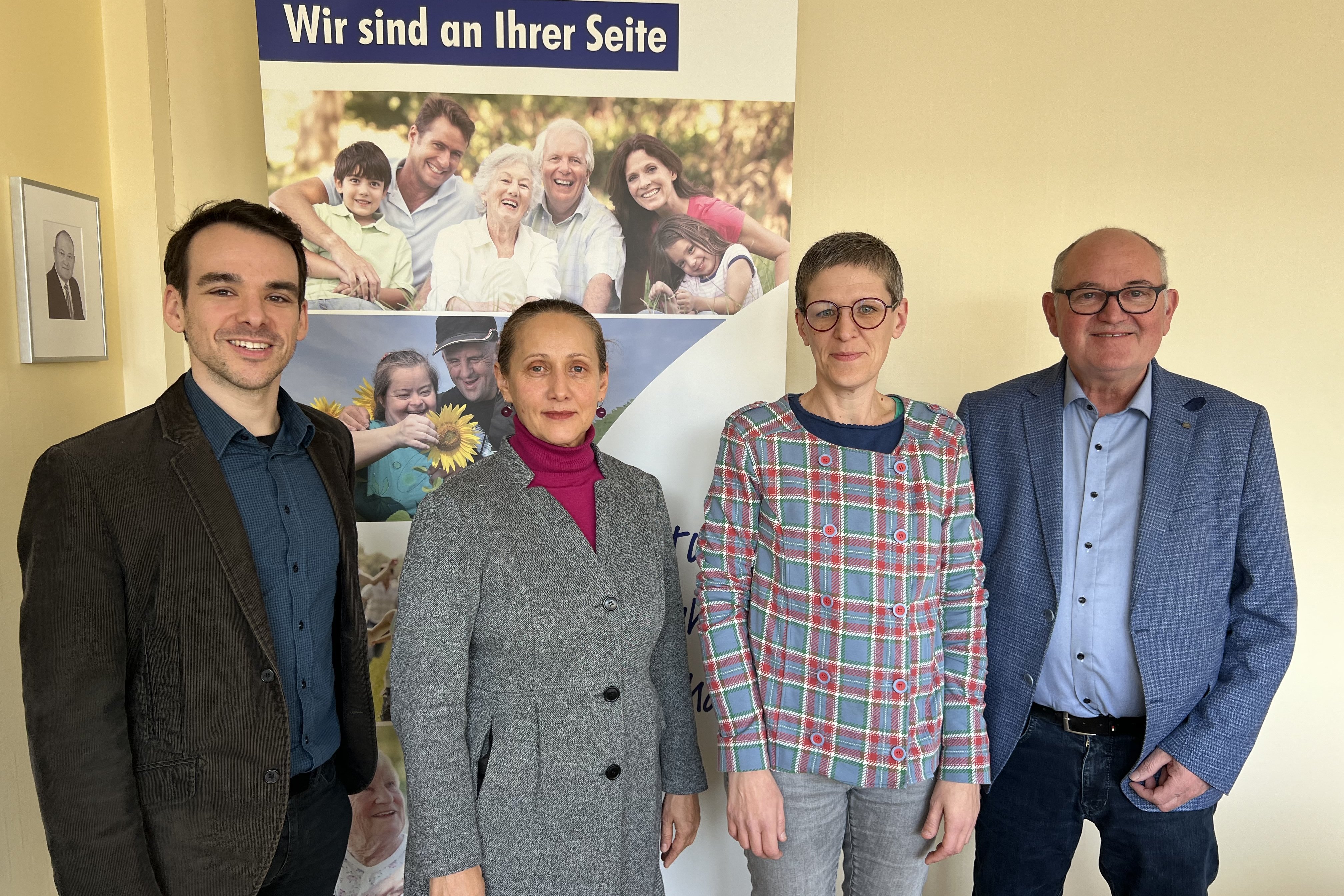 4 Personen stehen vor einer gelben Wand. Darunter Mitarbeiter des VdK Landesverbandes, die Stipendiatin und der Landesverbandsvorsitzender