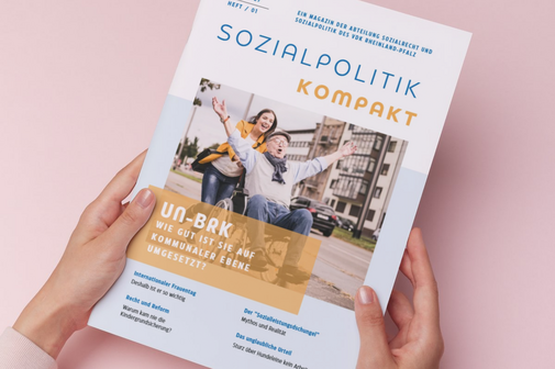 Hände halten ein Magazin fest.