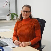 Eine Frau sitz an einem Schreibtisch.