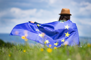 Eine persin hüllt sich in eine blaue Europaflagge.