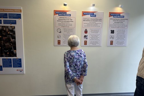 Eine Frau betrachtet Poster.
