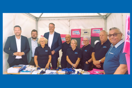 Acht Frauen und Männer stehen an einem Stand mit Flyern und vor VdK-Logos.