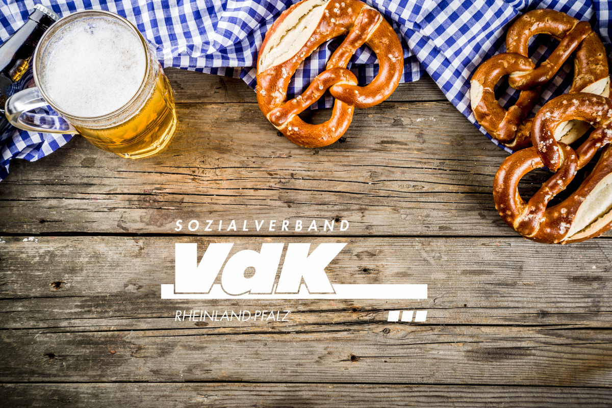 Herbstfest VdK Logo in weiß. Ein Bierglas und drei Laugenbrezel vor einer karrierten Tischdecke.