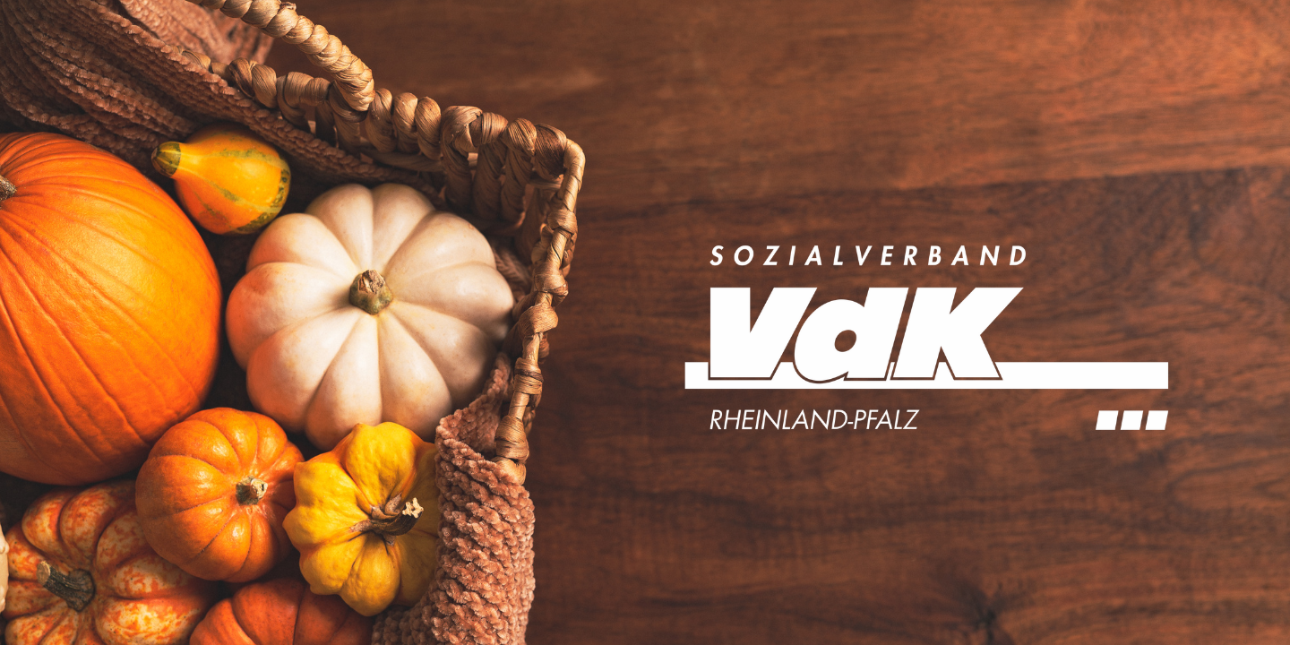 VdK-Logo vor braunem Hintergrund, neben einem Korb mit K&uuml;rbissen.