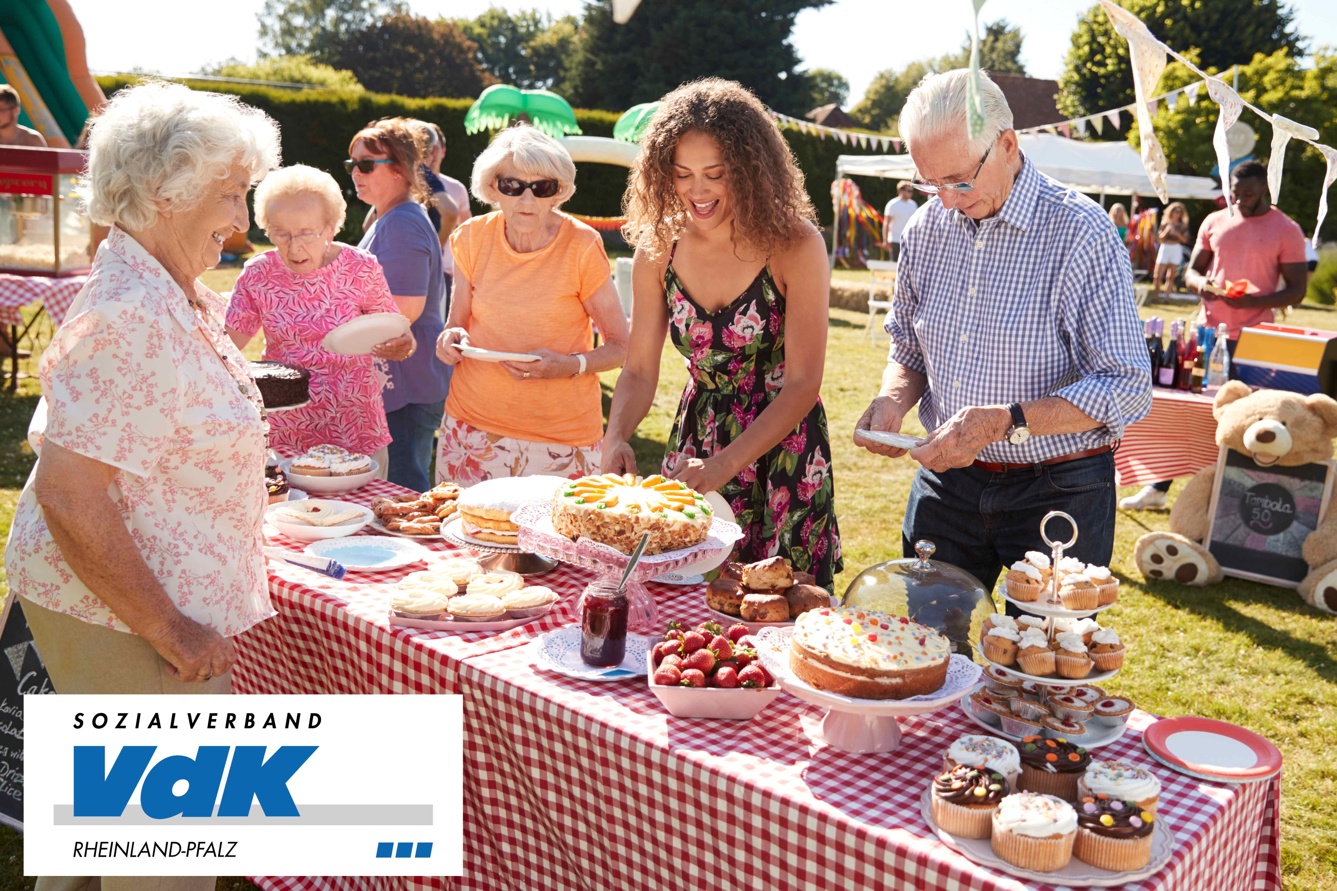 Menschen unterschiedlicher Generationen an einem Kuchenbuffet.