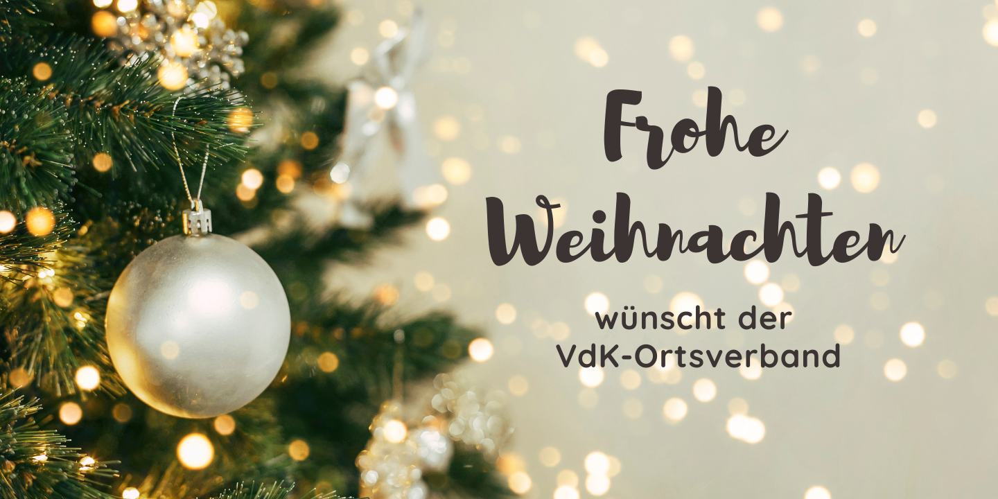 Weihnachtskugel an einem Tannenbaum und der Schriftzug: Frohe Weihnachten.