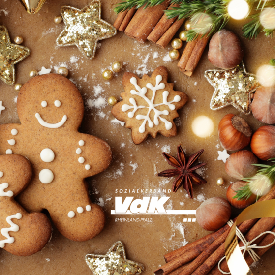 Symbolbild Adventszeit Lebkuchenmännchen, Zimtstangen, Plätzchen, Tannengrün, in der Mitte das VdK-Logo
