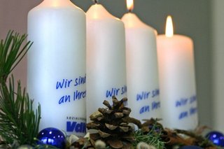 Vier Kerzen auf einem Adventsbesteck mit der Aufschrift "VdK - wir sind an Ihrer Seite"