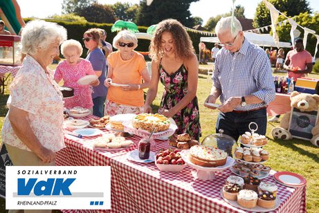 Menschen unterschiedlicher Generationen an einem Kuchenbuffet.