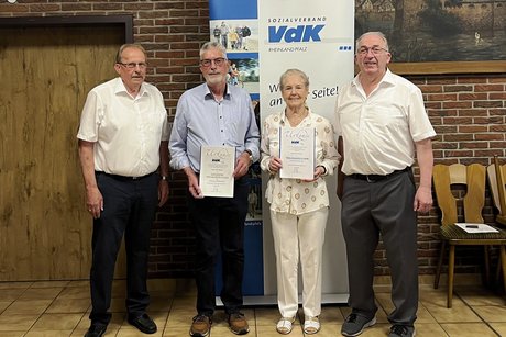 Der Stellv. Kreisvorsitzender Karl Erich Klöckner, Udo Geimer ( 50 Jahre), Renate Steinkuhl ( 40 Jahre), Ortsverbandsvorsitzender Friedhelm Schwinn hanen sich vor der VdK Tafel aufgestellt.