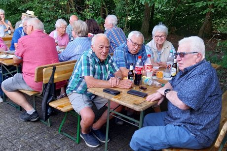 2. Bild von Mitgliedern mit Getränken am Tisch.