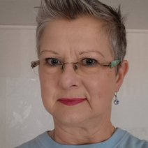 weibliche Person mit kurzen grauen Haaren, lächelt freundlich