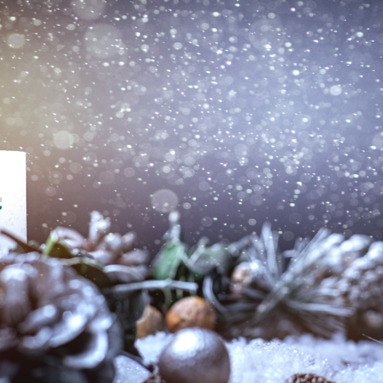 Kerze mit VdK-Logo und Weihnachtsdekoration.