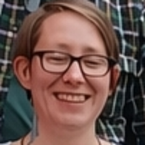 Freundlich l&auml;chelnde junge Dame mit Brille