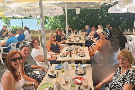 Personen an Tischen unter Schirmen