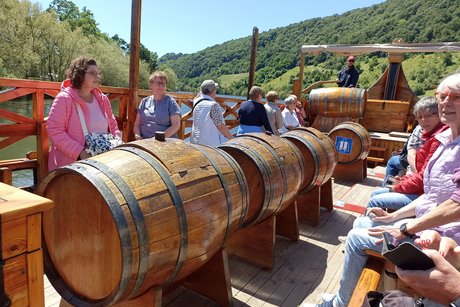 gemütliche Runde auf dem Schiff Personen auf dem Schiff mit Weinfässern