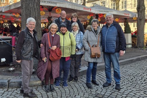 Mitglieder die mitgefahren sind vor einen Weihnachtsmarktstand.