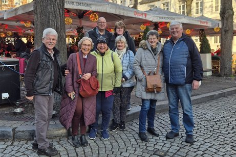 Mitglieder die mitgefahren sind vor einen Weihnachtsmarktstand.
