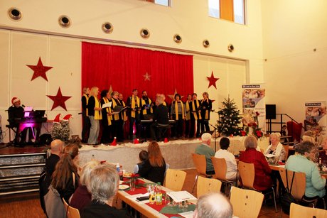 Potpourri an Eindrücken zur Weihnachtsfeier Gospelchor singt auf der Bühne Weihnachtslieder