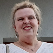 Blonde Frau mit Schalk im Gesicht