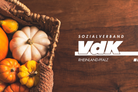VdK-Logo vor braunem Hintergrund, neben einem Korb mit K&uuml;rbissen.