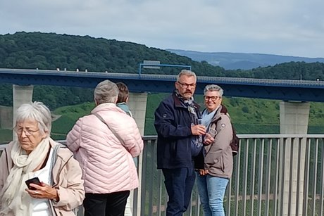 Reiseteilnehmer auf der Aussichtplatform und im Hintergrund der Hochmoselübergang. Mitreisende der Tagesfahrt und im Hintergrund der Hochmoselübergang.
