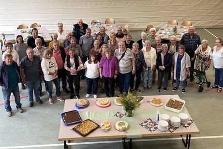 Gäste des Grillfestes vor der Kuchentafel