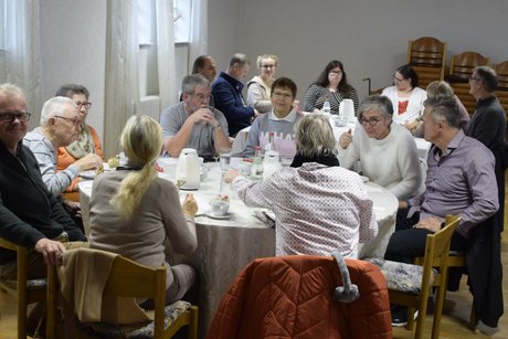 Menschen an zwei runden Tischen von vorn