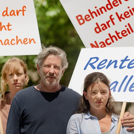 Gruppe von Menschen verschiedenen Geschlechts und Alters, mit und ohne Behinderung, demonstrieren. Auf den Demopappen steht "Pflege darf nicht arm machen", "Behinderung darf kein Nachteil sein" und "Rente f&uuml;r alle"