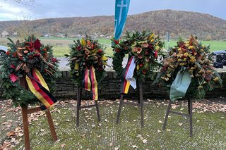 Vier Kränze stehen auf Ständern auf dem Soldatenfriedhof in Bad Bodendorf.