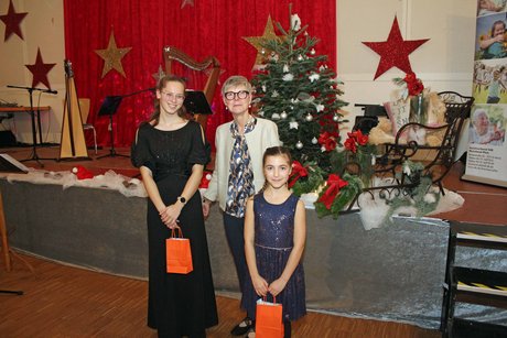 Potpourri an Eindrücken zur Weihnachtsfeier zwei Mädchen und eine Frau stehen in einer Gruppe zusammen