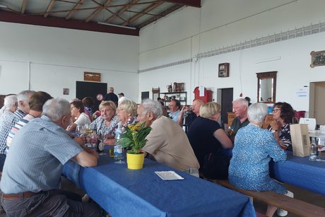 Menschen auf Bierbänken sitzend