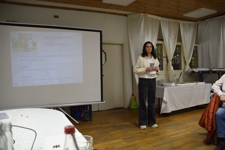 Frau Rapp beim Vortrag neben einer Leinwand