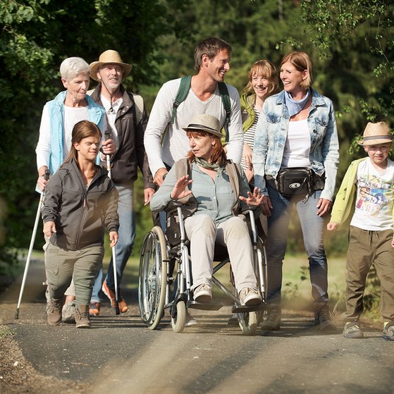 Eine Gruppe Menschen spaziert &uuml;ber einen Weg.